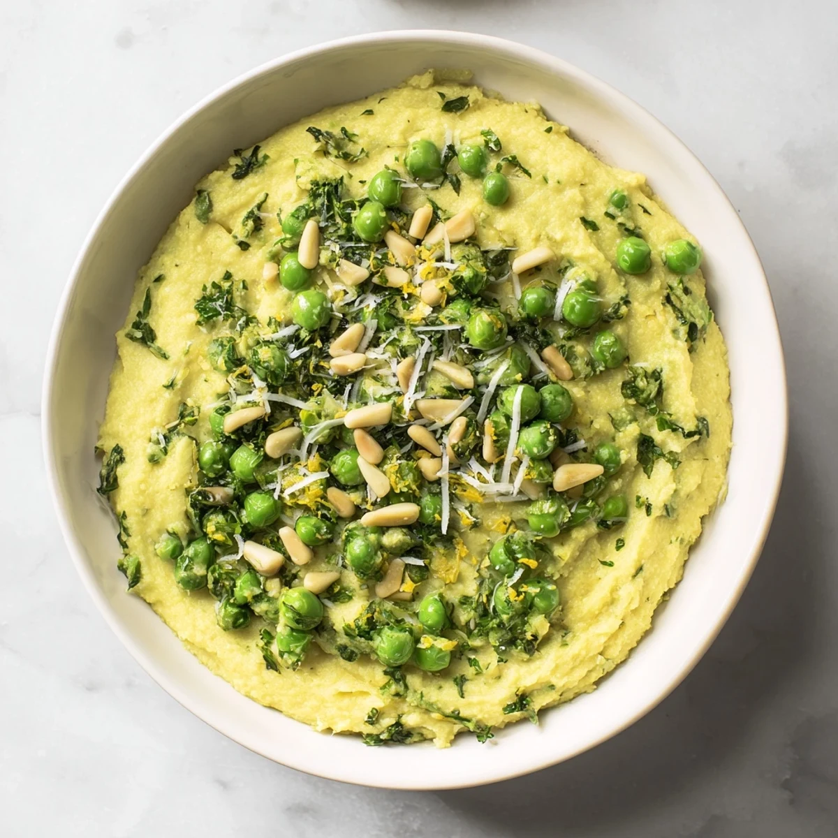 This warm plate of Green Pea & Spinach Pasta features toasted pine nuts and Parmesan atop.
