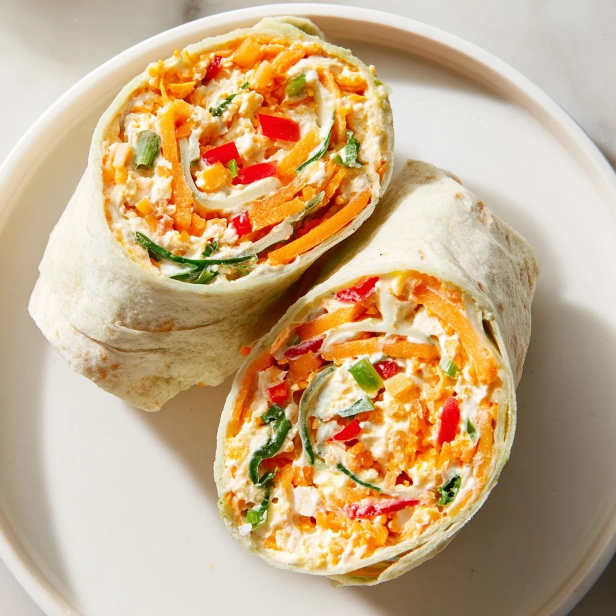 Sliced Cozy Scarf Holiday Pinwheel Wraps showcasing a spiral of cheese and veggie goodness, perfect appetizer.