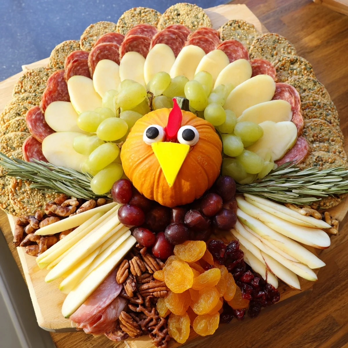 This Wheat Field Thanksgiving Turkey Board features a vibrant display of fruits, nuts, and crackers perfect for sharing.