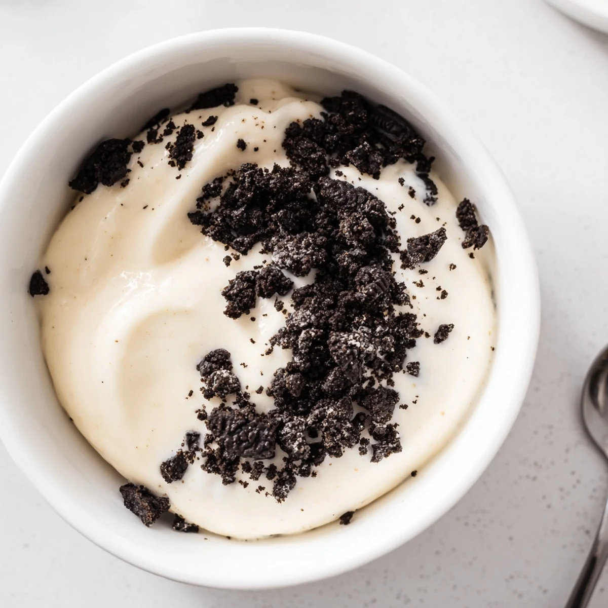 Enjoy a spoonful of delectable vanilla pudding with crushed Oreos, a simple, sweet American dessert.