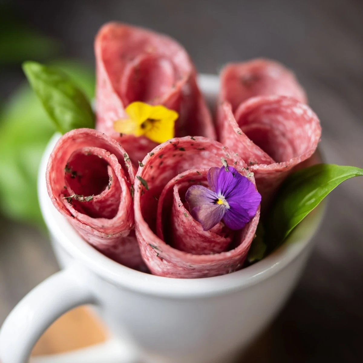 A delightful platter of The Victorian Tea Rose appetizer: savory salami and pepperoni roses arranged for a beautiful presentation.