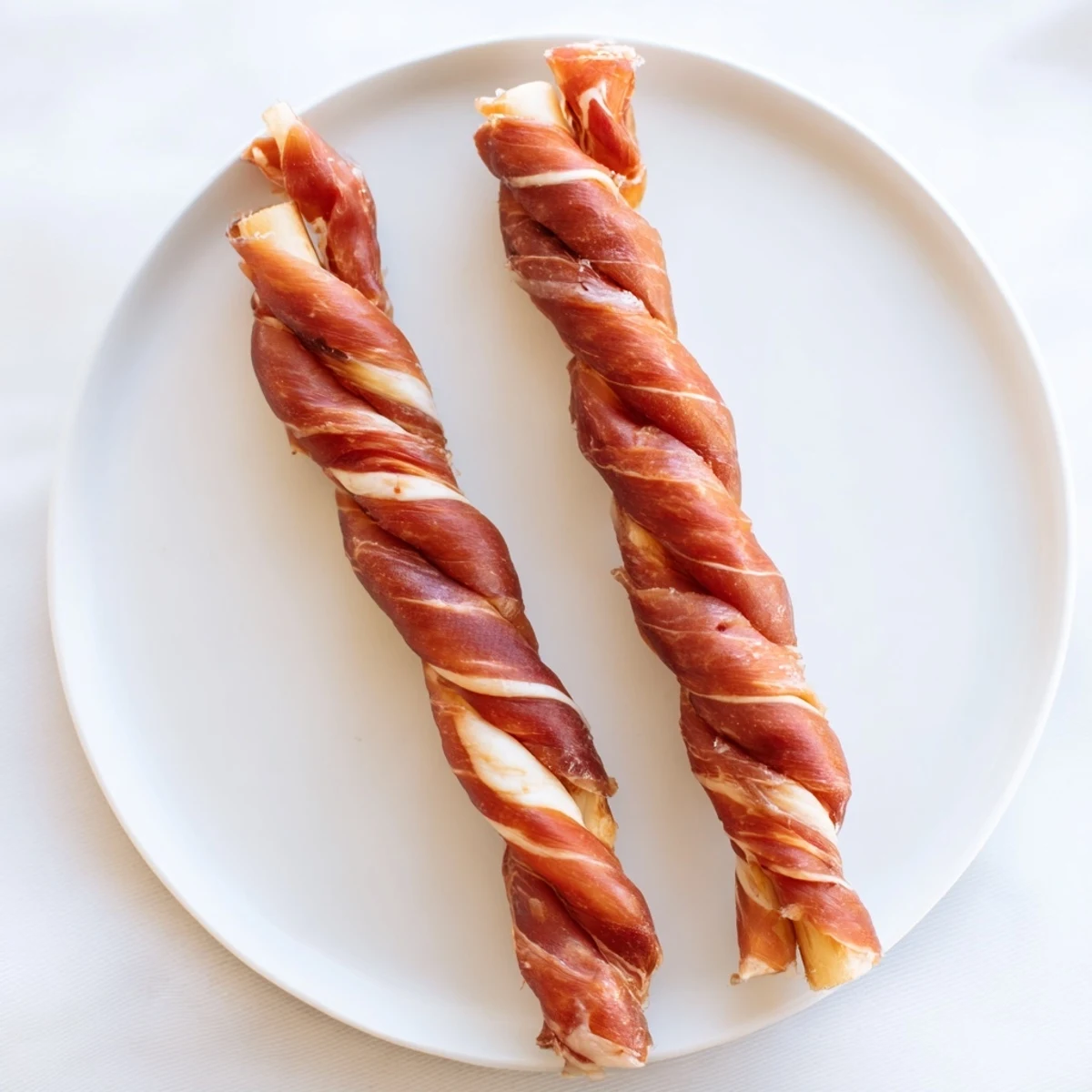 Savory Nautical Knots arranged on a flatbread, a simple appetizer with soft cheese and prosciutto.
