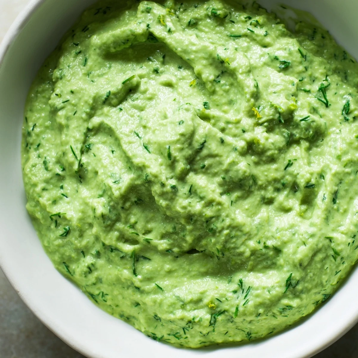 Fresh, creamy Green Goddess Dip with a vibrant green hue, perfect for dipping vegetables.
