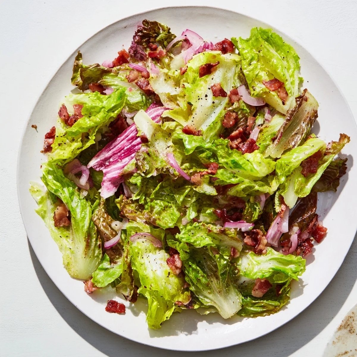 Vibrant Bitter Greens Salad with Warm Bacon Dressing, a delightful, savory starter, garnished with eggs.