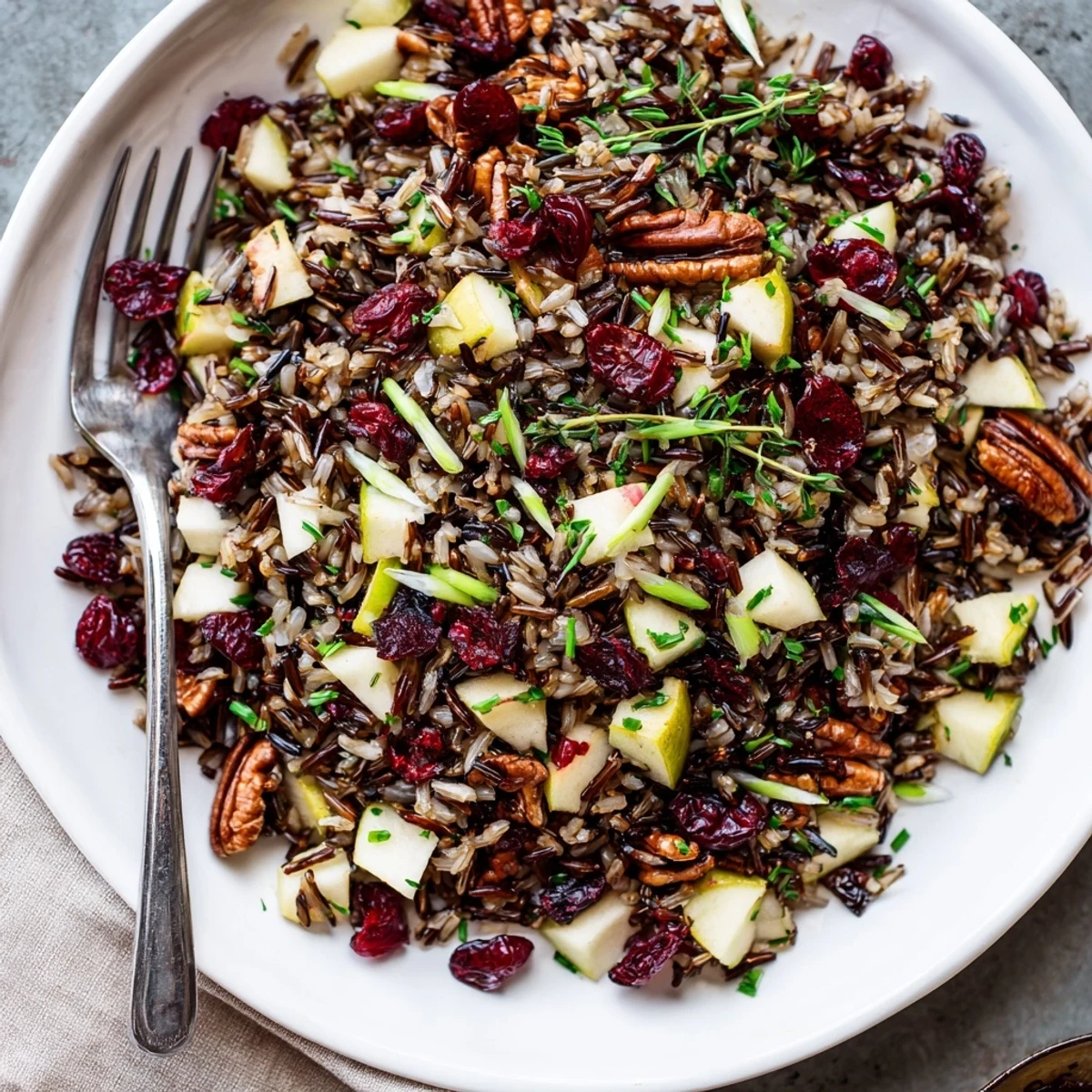 Tossing Wild Rice Harvest Salad with toasted pecans, cranberries, and herbs in a zesty vinaigrette.  