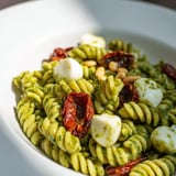This refreshing Pesto Pasta Salad includes toasted pine nuts, perfect for a summer picnic.