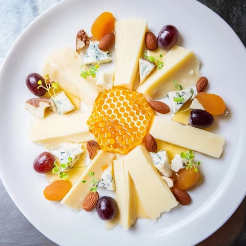 The Gilded Hive cheese board, featuring honey, cheese hexagons, and crackers, beautifully arranged for serving.