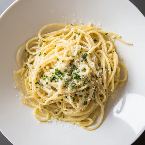 Steaming bowl of Miso Butter Pasta: creamy noodles coated with savory miso sauce and fresh chives.