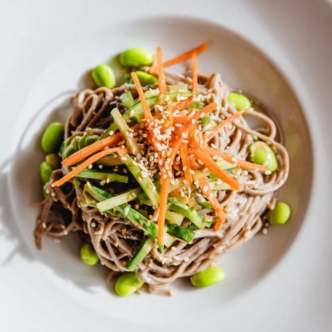 Vibrant Asian Sesame Noodle Salad, a flavorful cold noodle bowl topped with fresh herbs and peanuts.