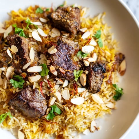 Steaming Qatari Majboos, the lamb and rice dish, garnished with fresh cilantro and toasted almonds.