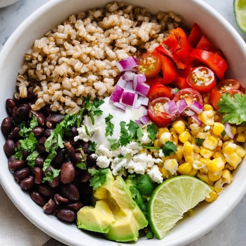 Vibrant Brown Rice Burrito Bowl with black beans, colorful peppers, and creamy queso fresco toppings.