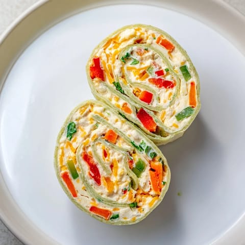 Freshly cut Cozy Scarf Holiday Pinwheel Wraps on a platter, ready to be served at your holiday party.