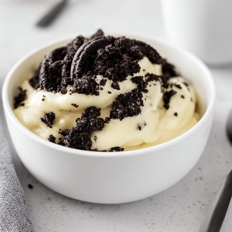 A close-up shot of rich vanilla pudding with crushed Oreos, ready to be enjoyed.