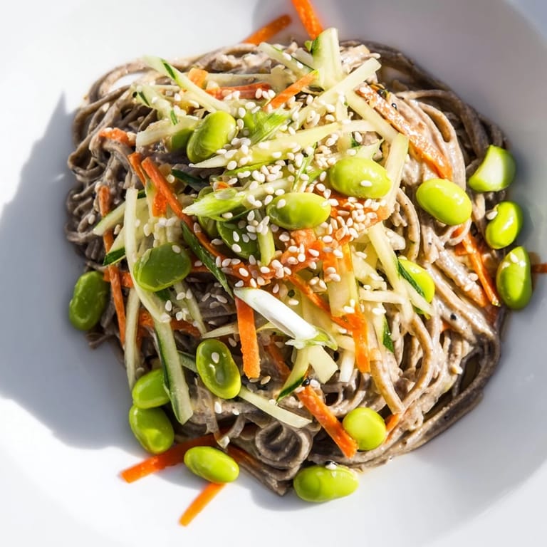 A close-up view of Asian Sesame Noodle Salad with visible noodles and carrots in a delicious sauce.