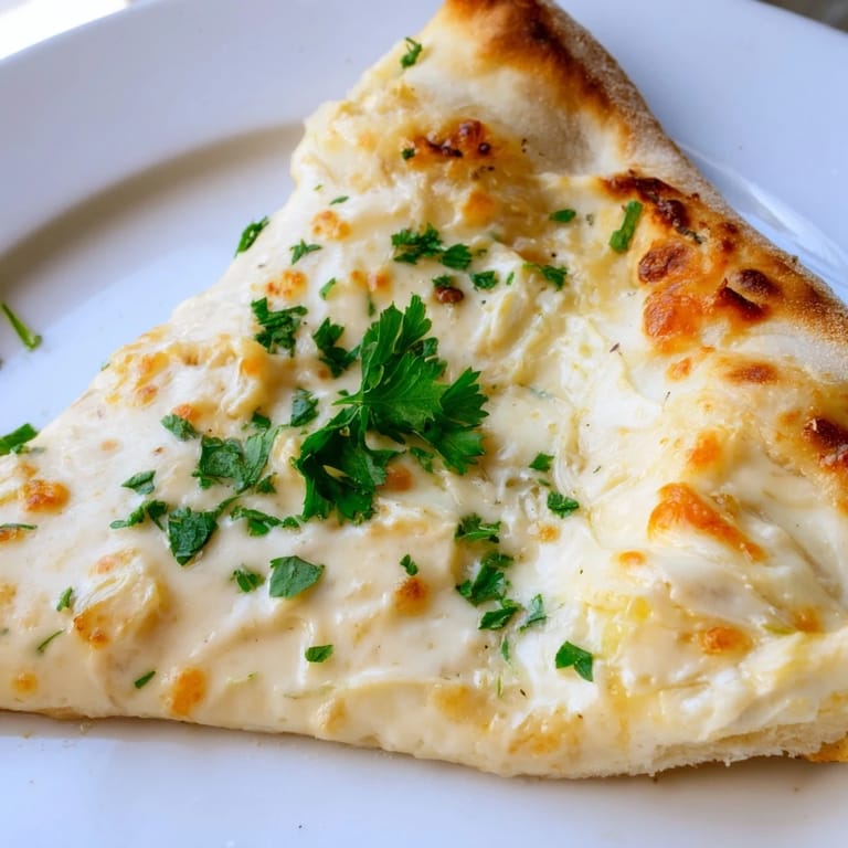 Golden-brown Creamy Garlic White Pizza on a wooden board, ready to slice for a vegetarian dinner.