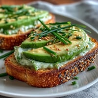 Shamrock avocado toast with everything seasoning, a festive St. Patrick's Day breakfast idea with fresh avocado and crunchy topping.